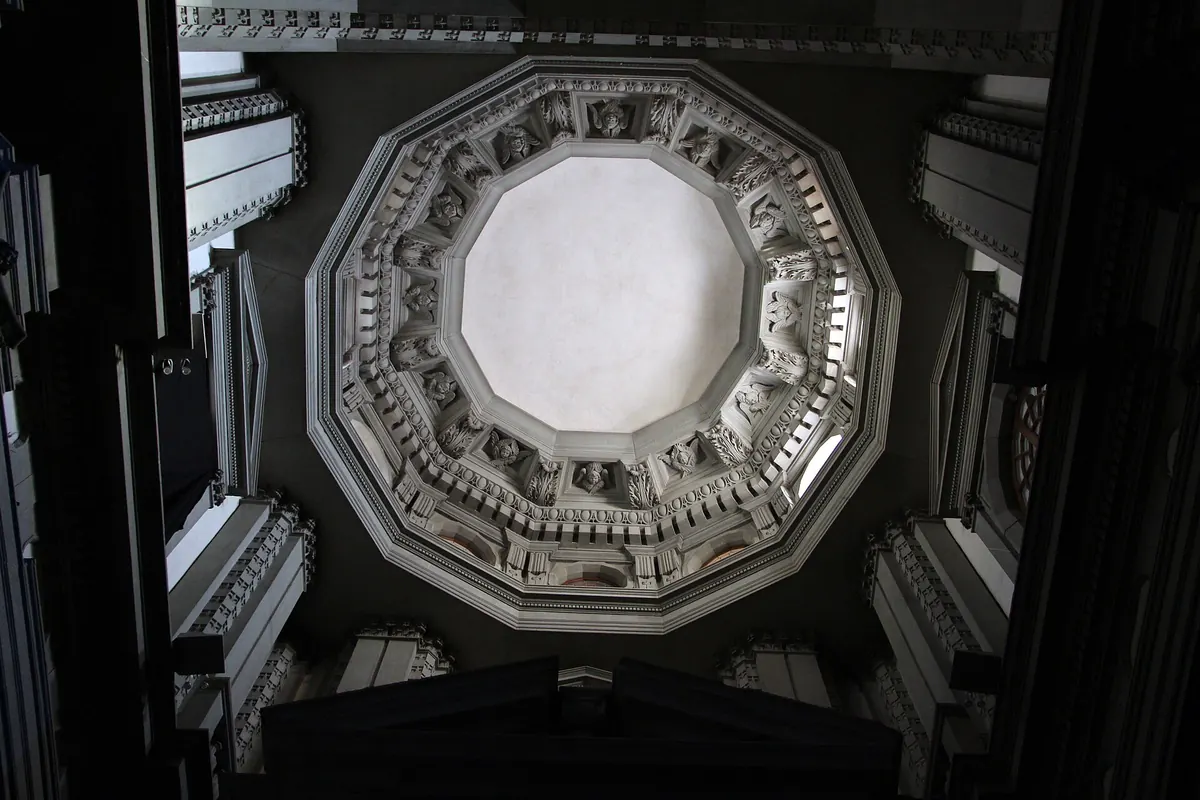 Looking up into the twelve-sided dome of Santo Stefano al Ponte in Florence, with a white oculus ringed by plaster mouldings